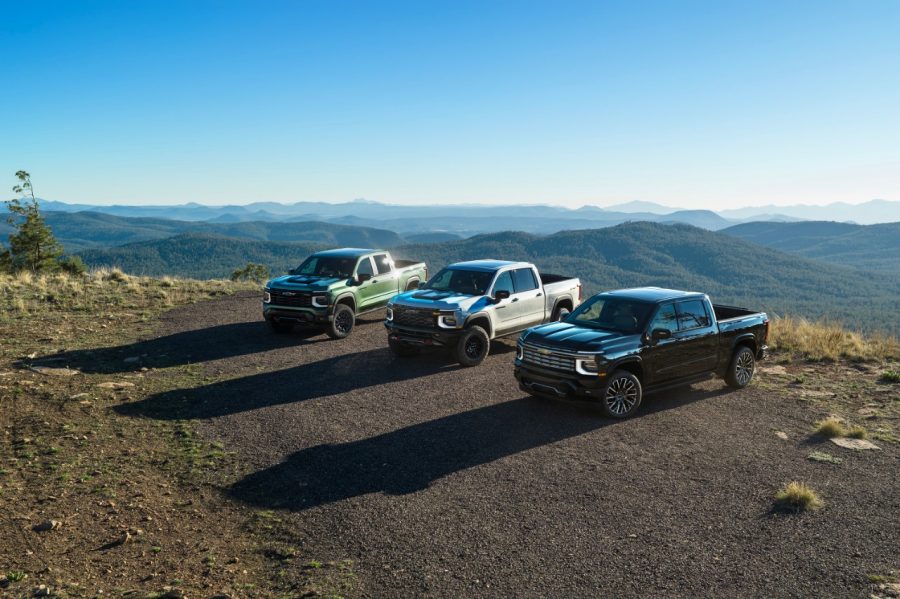 Pack shot of 2027 Chevrolet Silverado 1500 Trail Boss in Trillium Metallic, ZR2 in White Sands, and High Country in Black. (Left to Right) Three 2027 Chevrolet Silverado 1500 trucks